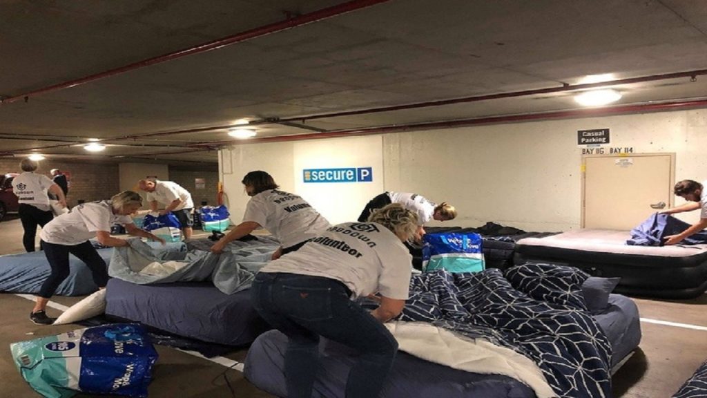 Volunteers Setting Up Sheets for Beds in Parking - Charities For the Homeless - Beddown